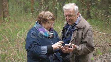 一对老夫妇在智能手机上看孙辈的照片。 微笑和欢笑，<strong>体验快乐</strong>。 彼此相爱